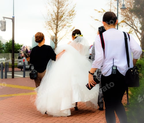 Preview: A white-dressed bride with an entourage of photographers