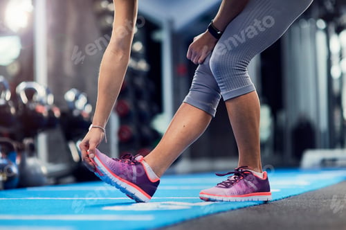 Preview: Waist down view of young woman touching toes on gym mat