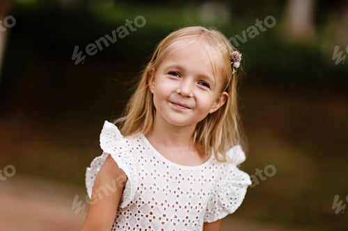 Preview: Portrait of cute little Caucasian girl five years old with blonde hair smiling outdoor in park