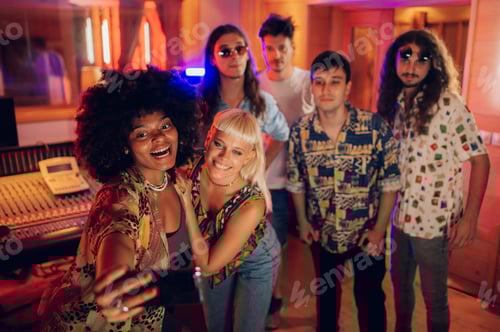 Preview: Diverse group of musicians taking selfies at music recording studio.