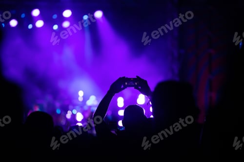 Preview: Abstract photo of crowd at concert and blurred stage lights.