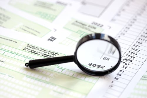 Preview: German different tax forms and magnifying glass pointed on 2022 inscription