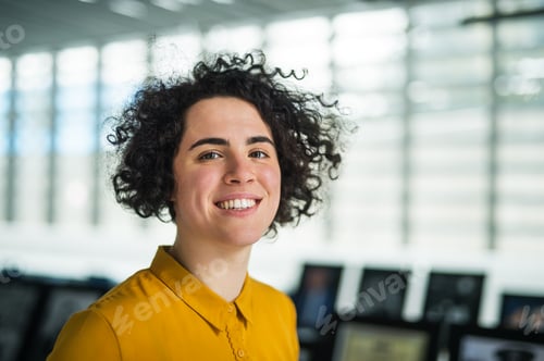 Preview: Portrait of a young student or businesswoman in room in a library or office.