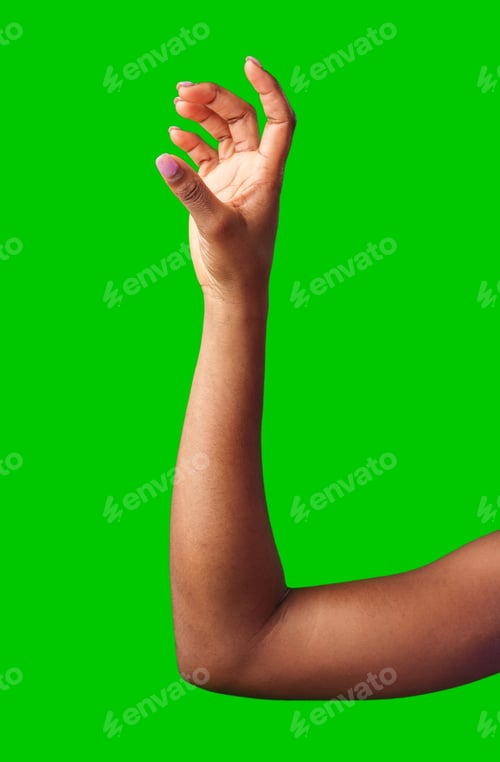 Preview: A hand making a gesture with a green background during daylight