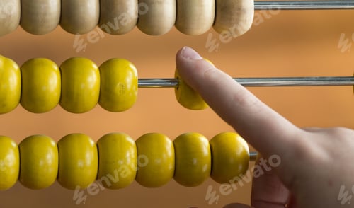Vista previa: Closeup shot of a child hand used a wooden abacus at home