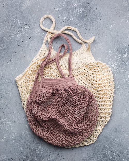 Preview: Vertical closeup shot of beige and pink knitted bags