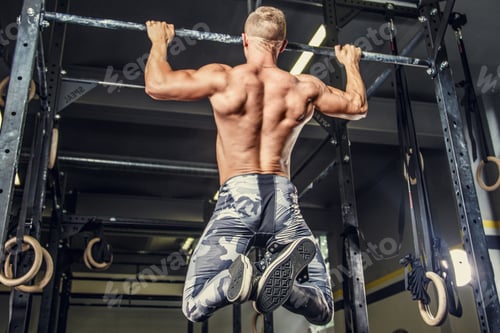 Preview: Shirtless man pulling up on horizontal bar.