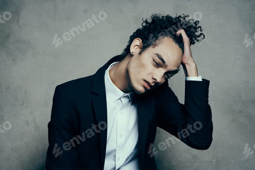 Preview: curly haired guy in a suit sitting on a chair fashion modern style jacket