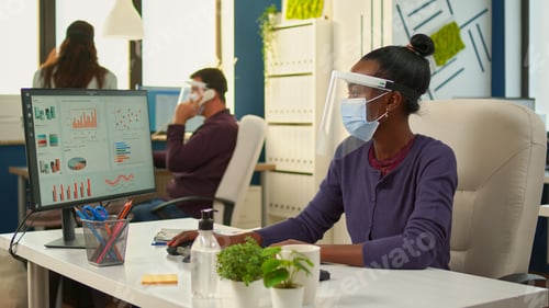 Preview: African workers with face mask writing on pc and looking on camera