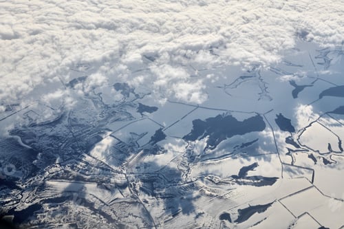 Preview: Aerial cloudscape view over clouds top to snow covered rivers, roads, cities and fields, winter air
