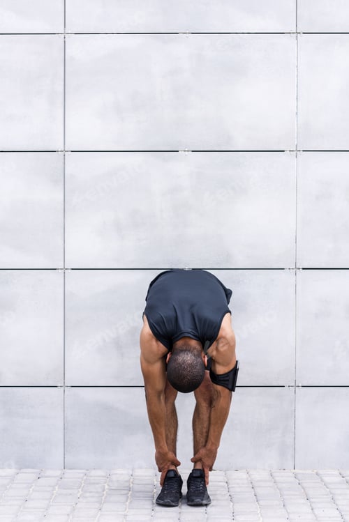 Vista previa: young african american sportsman stretching before training on street
