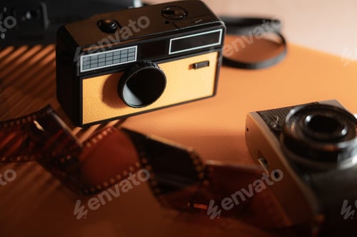 Preview: Vintage Camera and Film Roll on Orange Background