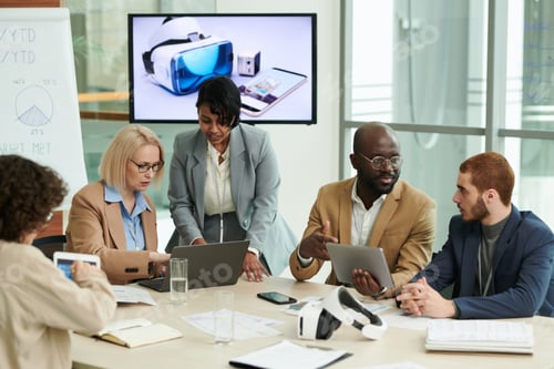 Preview: Group of intercultural coworkers with mobile gadgets discussing working points