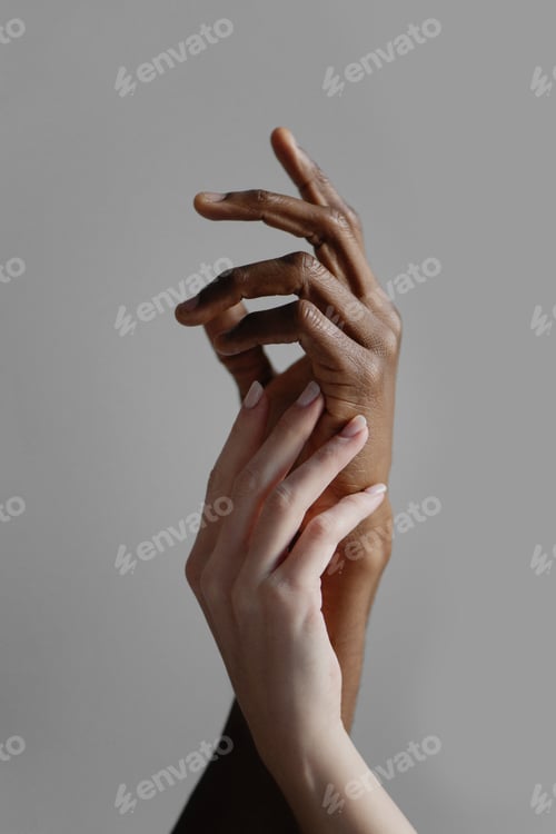 Preview: Hands of interracial couple on grey background.