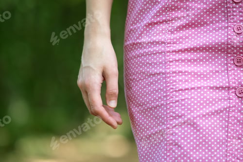 Preview: Close up of woman hand and pink dress
