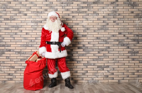 Preview: Authentic Santa Claus with big red bag full of gifts near brick wall