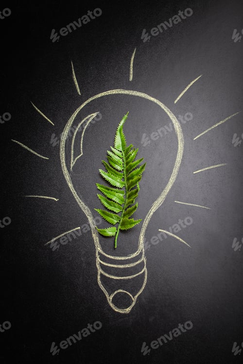 Preview: Green leaf inside lightbulb hand-drawn on black chalk board