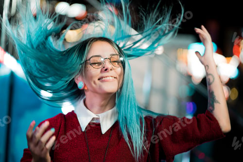 Preview: Happy hipster girl playing with blue dyed hair