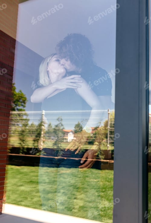 Preview: Couple kissing behind the window