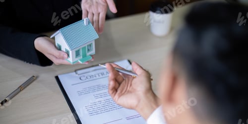 Preview: Real Estate Agent and Buyer Reviewing Contract with House Model