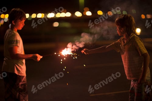 Vista previa: Dos niños jugando con bengalas el 4 de julio