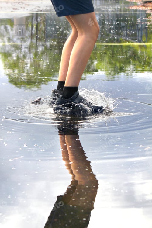 Preview: Boy jumping in a puddle