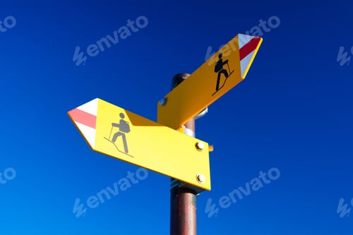 Preview: Hiking and traveling in the mountains. Directional marker for a mountain hike. Yellow bright sign