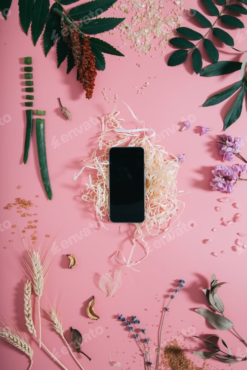 Preview: Creative top view of phone mock up on pastel millennial pink paper background.