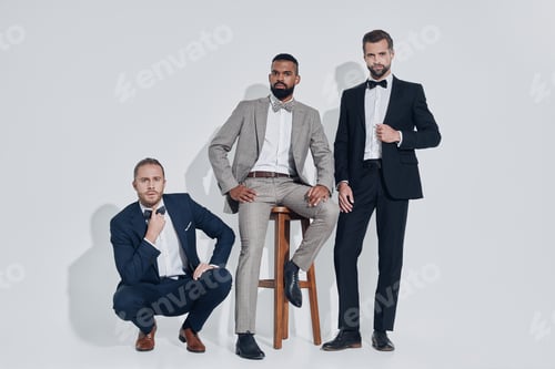 Preview: Three handsome young men in suits and bowties looking at camera
