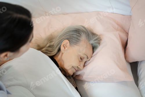 Preview: Nurse support supporting senior woman on bed in bedroom at nursing home.