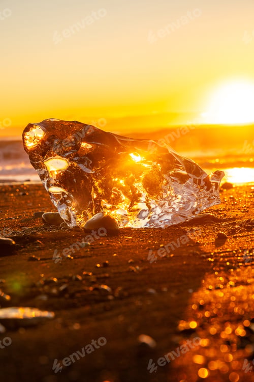 Preview: Beautiful sunrise with ice on Diamond Beach next to Jokulsarlon in winter in Iceland