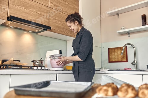 Preview: young mixed race woman is cooking a marshmallow at home