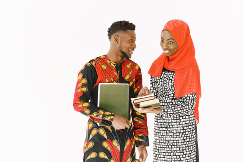 Preview: African students in traditional clothes with book in white studio
