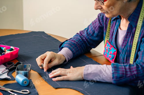 Preview: Senior female seamstress sewing cloth