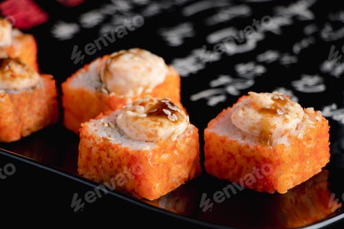 Preview: Sushi rolls with caviar on black plate. Serving Japanese food