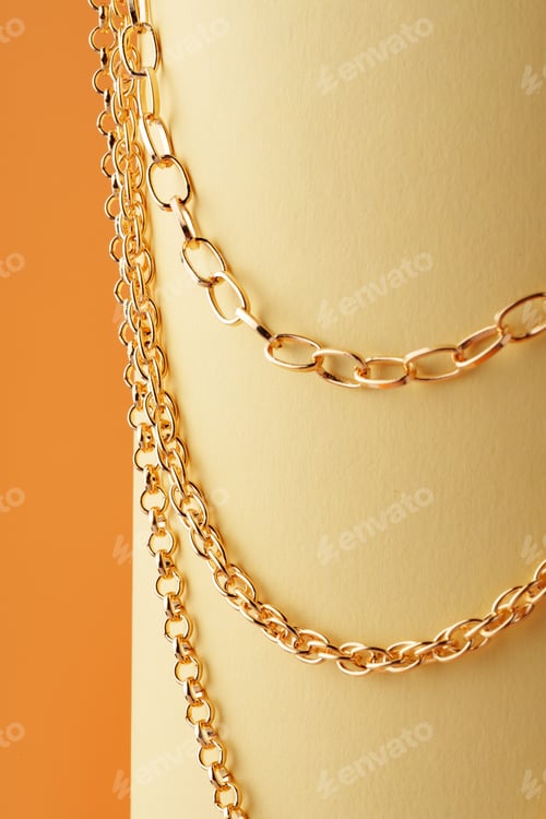 Preview: Golden chain on display on yellow background