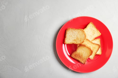 Preview: Plate with toasted bread on grey background, top view