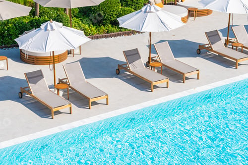 Preview: Umbrella and deck chair around outdoor swimming pool in hotel resort