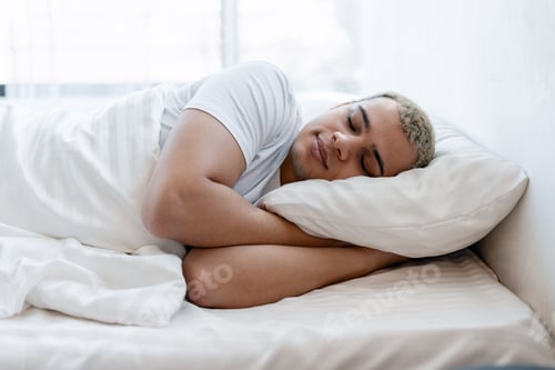 Preview: Young man relaxing in bed sleeping, finding comfort and peaceful rest