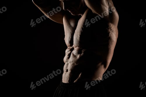 Preview: torso of attractive male body builder on black background.