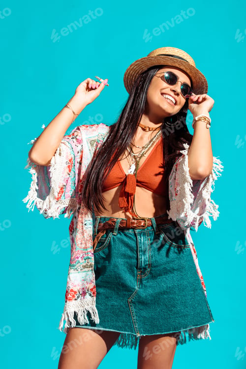 Preview: Attractive bohemian girl smoking cigarette and dancing isolated on turquoise