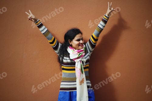 Preview: Enthusiastic woman by orange background wall