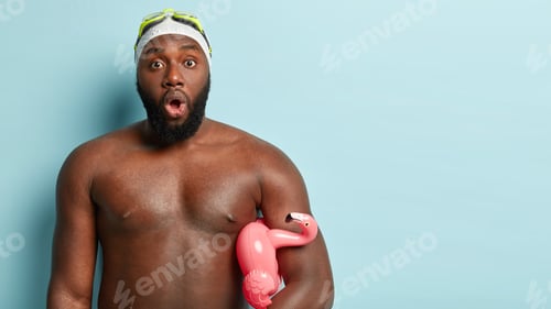 Preview: Impressed black man with strong muscular body, spends free time doing favourite hobby, wears goggles