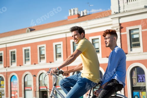 Preview: Young gay male couple enjoying a bike ride outdoors