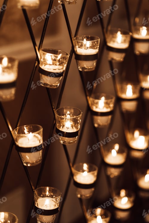 Preview: Candles burn in glasses on the wedding arch