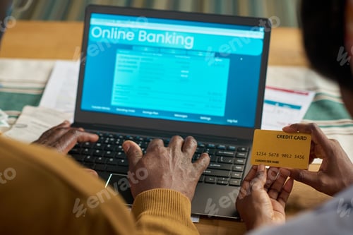 Preview: Middle Aged Black Man Using Laptop and Credit Card for Online Tax Payment