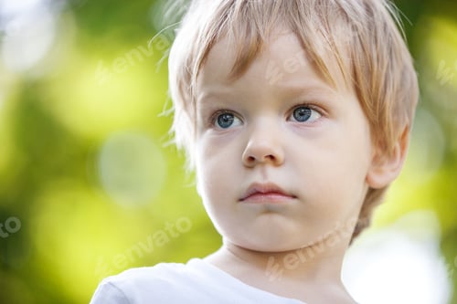 Preview: Portrait of a cute boy in a pensive mood against green background