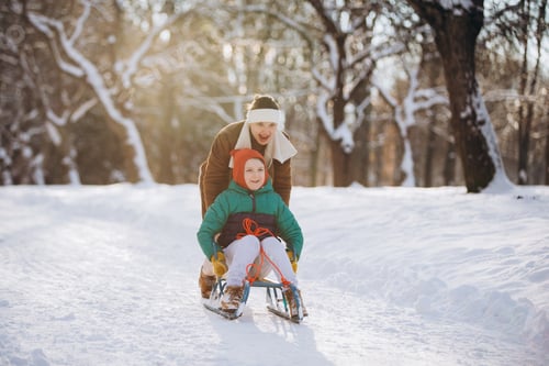 Preview: Mother and son sledding in winter park