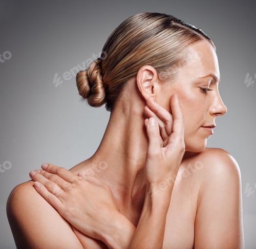 Preview: Beautiful mature woman posing in studio against a grey background