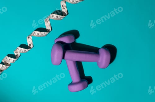 Preview: Purple dumbbells and tape measure on a blue background. Fitness concept, weight loss, diet